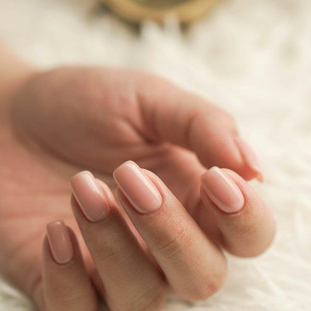 Tangan dengan kuku manikur pink muda